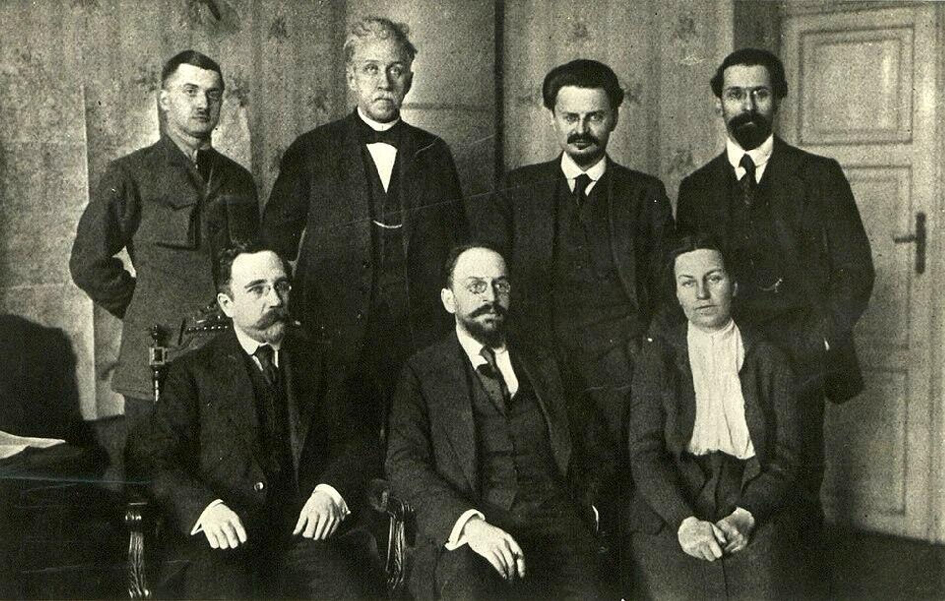 Советская делегация в Бресте, 1918 год (стоят - Владимир Липский, Пётр Стучка, Лев Троцкий, Лев Карахан; сидят - Лев Каменев, Адольф Иоффе, Анастасия Биценко) Советская делегация в Бресте, 1918 год (стоят - Владимир Липский, Пётр Стучка, Лев Троцкий, Лев Карахан; сидят - Лев Каменев, Адольф Иоффе, Анастасия Биценко) - РИА Новости, 1920, 11.12.2025