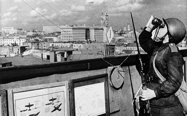 Девушка-военнослужащая войск МПВО на боевом дежурстве. Москва, 1943 год (На заднем плане видны здание наркомата обороны на Знаменке и колокольня Иван Великий в Кремле) Девушка-военнослужащая войск МПВО на боевом дежурстве. Москва, 1943 год (На заднем плане видны здание наркомата обороны на Знаменке и колокольня Иван Великий в Кремле)
