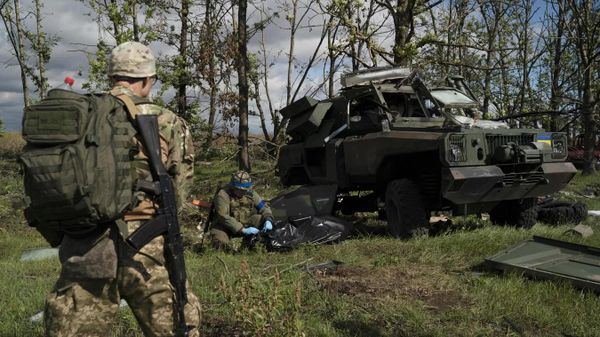 Украинские военнослужащие рядом с уничтоженным бронетранспортером ВСУ в Харьковской области
