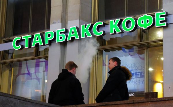 Мужчины у кафе Старбакс.
