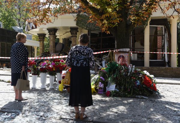 Женщины возлагают цветы к зданию кафе Сепар в Донецке, где произошел взрыв в результате которого погиб глава ДНР Александр Захарченко