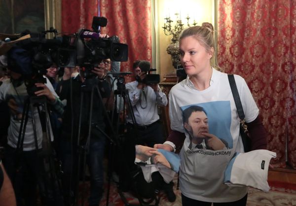 Активистка раздает футболки в поддержку руководителя портала РИА Новости Украина Кирилла Вышинского перед встречей министра иностранных дел РФ Сергея Лаврова с генеральным секретарем ОБСЕ Томасом Гремингером